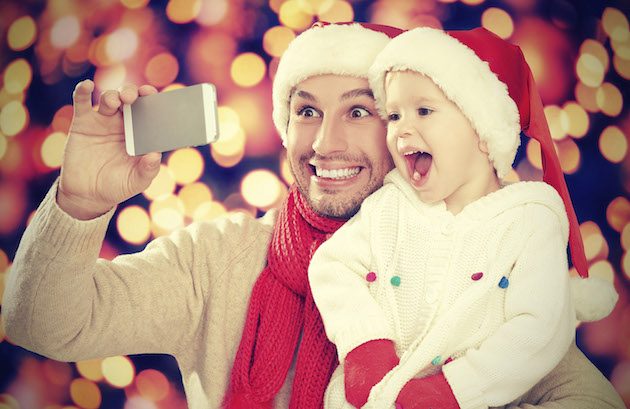 Christmas Day Lunch at the North Pole: selfe in Christmas. happy family dad playing with daughter and photographed on mobile phone