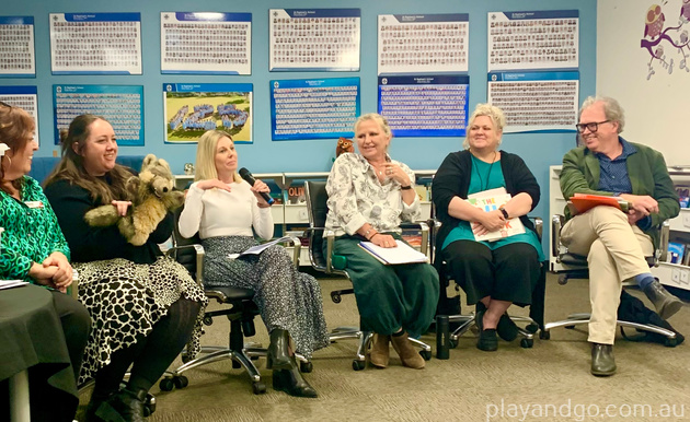 Bec Hughes from Raising Literacy Australia speaks while the panel watches on. Caitlin Hadrill from Unley Library holds a puppet next to her.